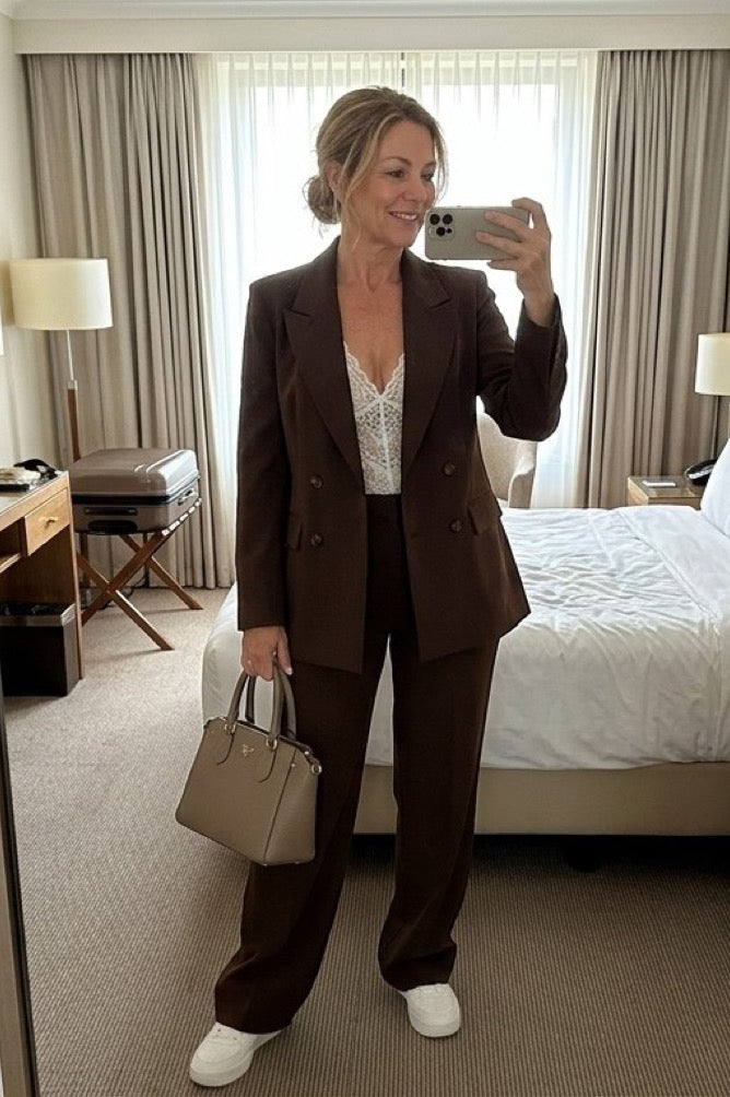 Mujer con traje marrón de chaqueta y pantalón